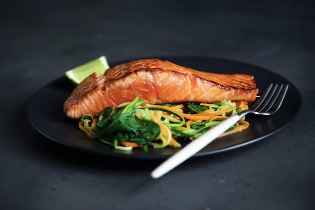 Thin green matcha crepes filled with smoked salmon and cream cheese, garnished with fresh herbs.
