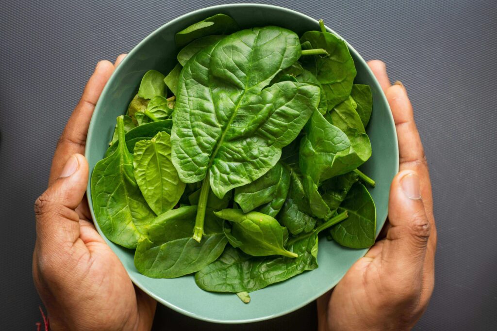 Green protein-packed pancakes made with matcha, spinach, and fresh herbs, served on a plate.